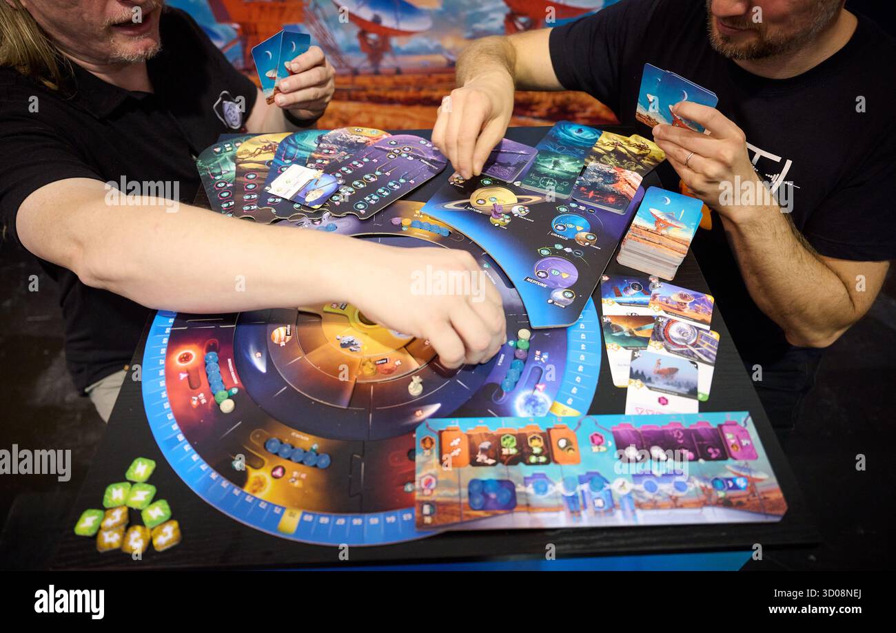 Essen, Deutschland. Oktober 2025. Petr Murmak (l) und Spieleentwickler Tomas Holek demonstrieren ihr Spiel „SETI: Auf der Suche nach außerirdischem Leben“, das zuvor mit dem Deutschen Spiele-Preis ausgezeichnet wurde, während der Medientour der internationalen Verbrauchermesse „Spiel Essen 2025“ auf der Messe Essen. Nach Angaben der Veranstalter werden ab 23. Oktober rund 200.000 Besucher aus mehr als 80 Ländern an der weltweit größten öffentlichen Brettspielmesse teilnehmen. Quelle: Bernd Thissen/dpa/Alamy Live News Stockfoto