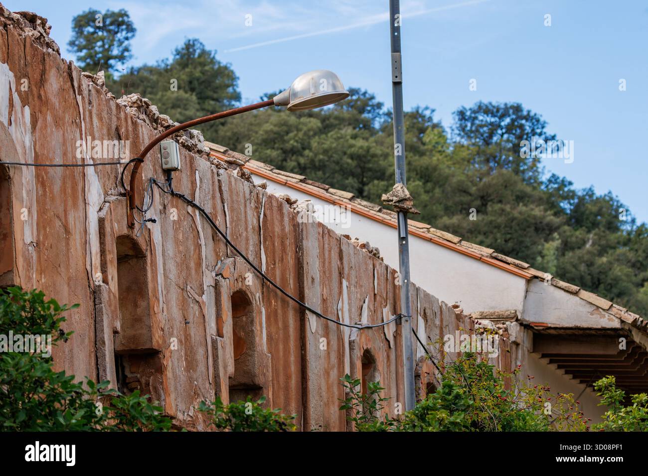 Eine einsame Straßenlaterne kommt von der Ruine eines alten Gebäudes in Font Roja, Alcoy, Spanien Stockfoto