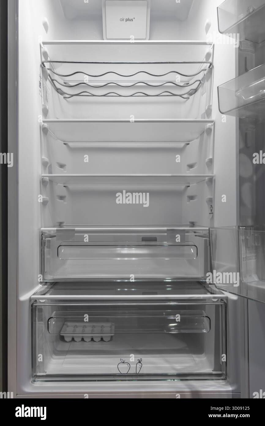 Öffnen Sie den leeren Kühlschrank mit blauer LED-Leuchte und Glasböden. Sauberes und modernes Haushaltsgeräteinnere, bereit für die Aufbewahrung von Lebensmitteln in einem modernen Stockfoto