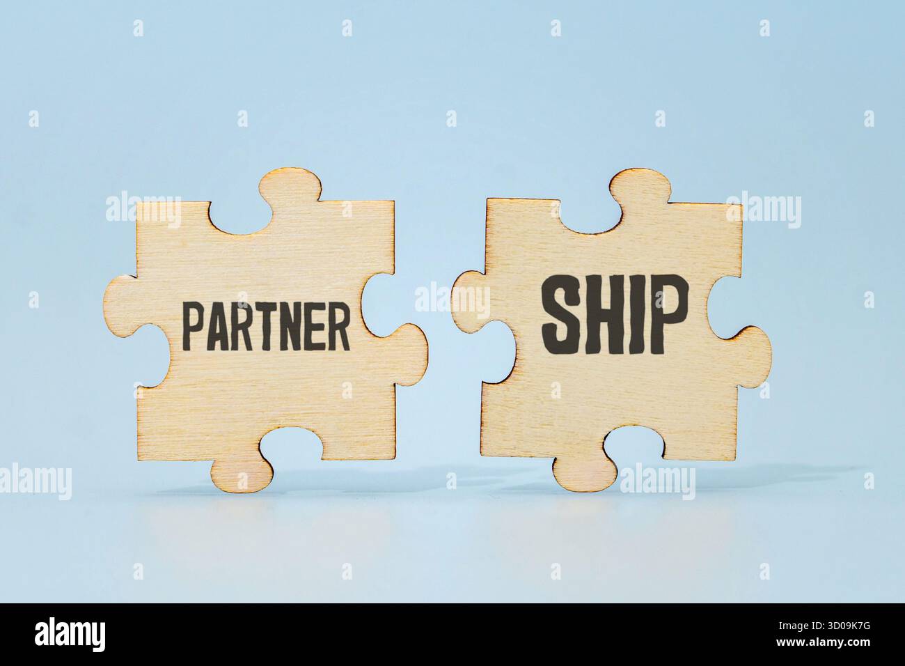 Zwei Puzzleteile bilden das Wort „PARTNERSCHAFT“. Konzept für Zusammenarbeit und Teamarbeit. Stockfoto