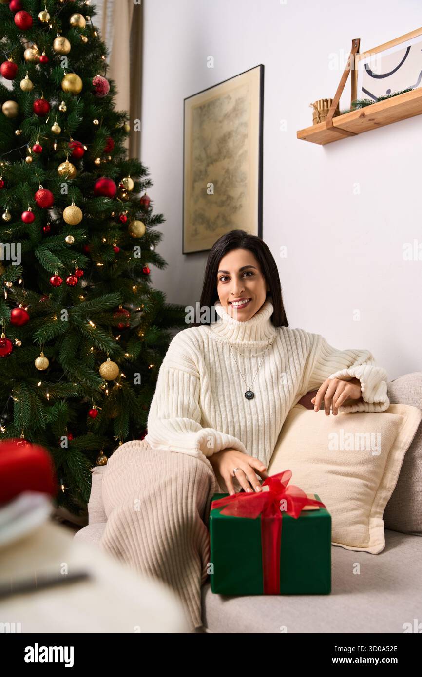 Eine Frau genießt den Weihnachtsgeist umgeben von Dekorationen und einem wunderschön beleuchteten Baum. Stockfoto