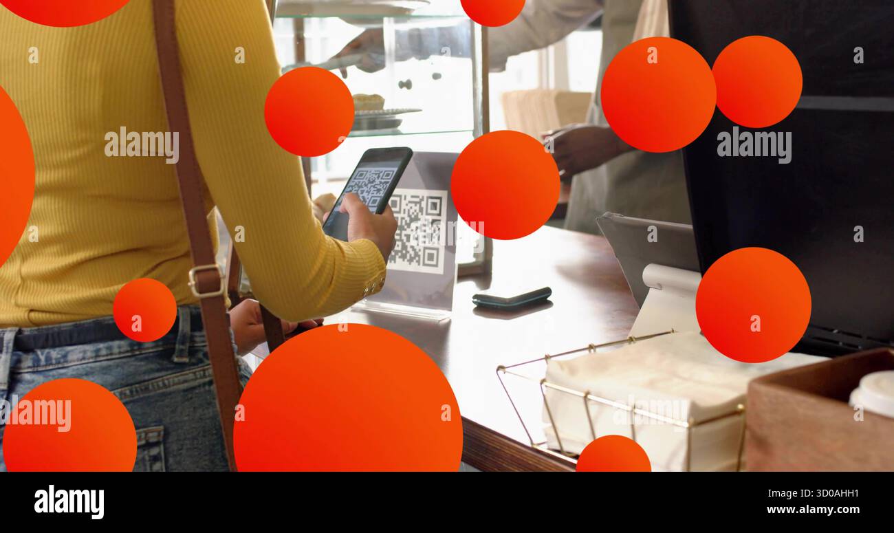 Mit Smartphone-Frau mit gelbem Oberteil, das QR-Code-Schild am Cafeteschalter mit Kartenleser scannt Stockfoto