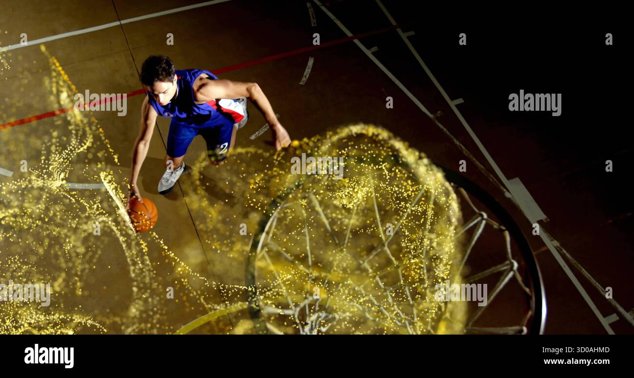 Springender Spieler mit blauem Trikot, der Basketball über dem Platz hält, mit Basketballnetz und goldenem Trail Stockfoto