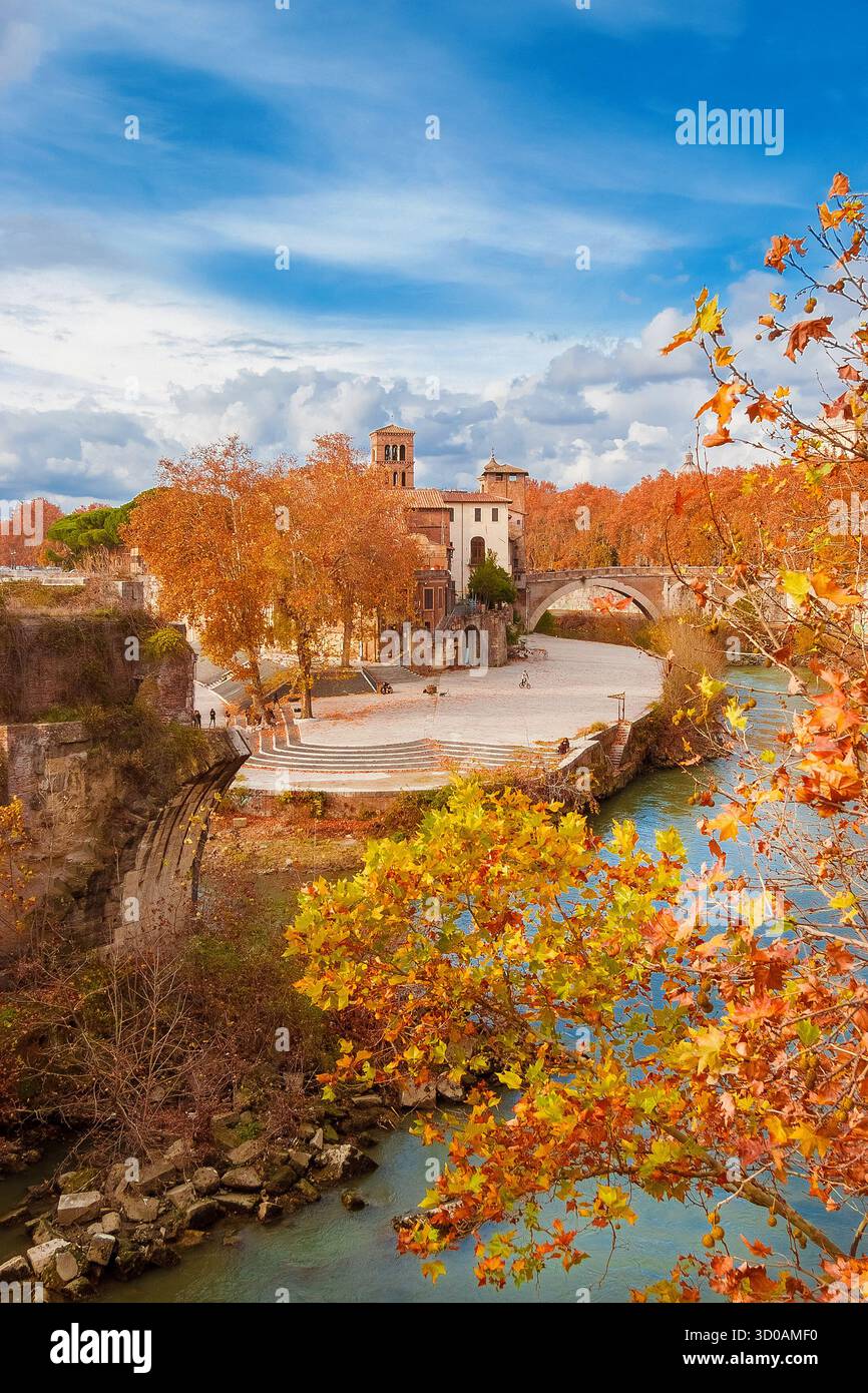 Herbst und Laub in Rom. Orangene und gelbe Platanen in der Nähe der Tiberinsel mit einer alten römischen Brücke im historischen Zentrum der Stadt Stockfoto Herbst und Laub in Rom. Orangene und gelbe Platanen in der Nähe der Tiberinsel mit einer alten römischen Brücke im historischen Zentrum der Stadt Stockfoto
