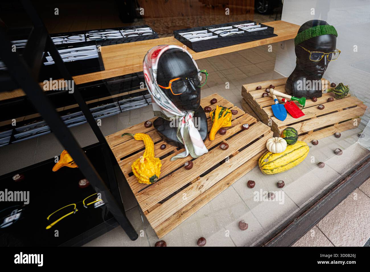 Tarnow, Polen - 10. Oktober 2025: Schaufensterpuppen mit Tüchern und Sonnenbrillen in einer Einzelhandelsausstellung unter Kürbissen und Gartengeräten in Tarnow Polen. Stockfoto