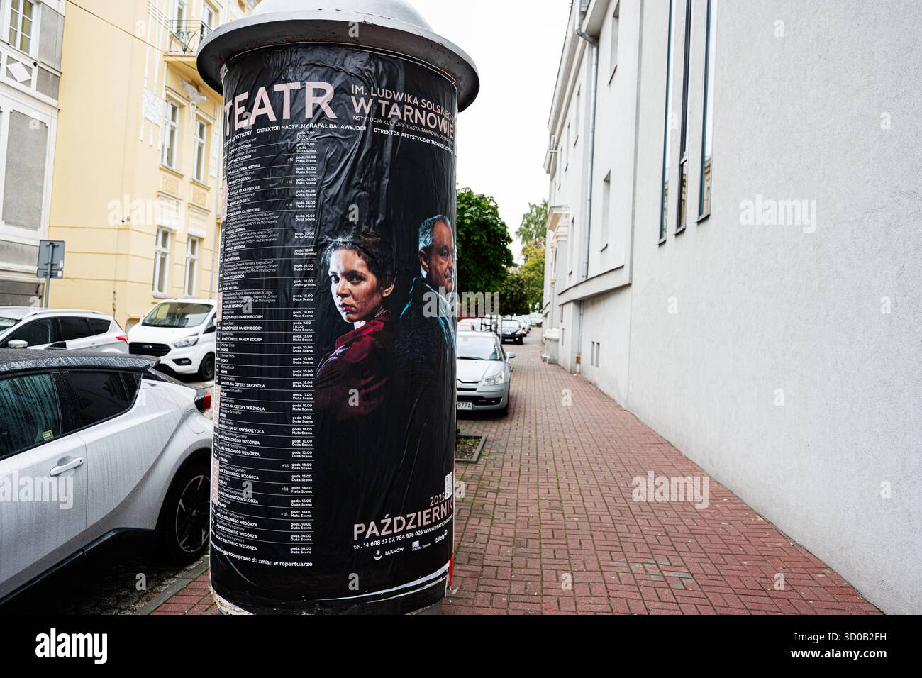 Tarnow, Polen - 10. Oktober 2025: Werbeplakat über einer Straßensäule in Tarnow, Polen, in der Nähe von Parkwagen und hellen Gebäuden. Stockfoto