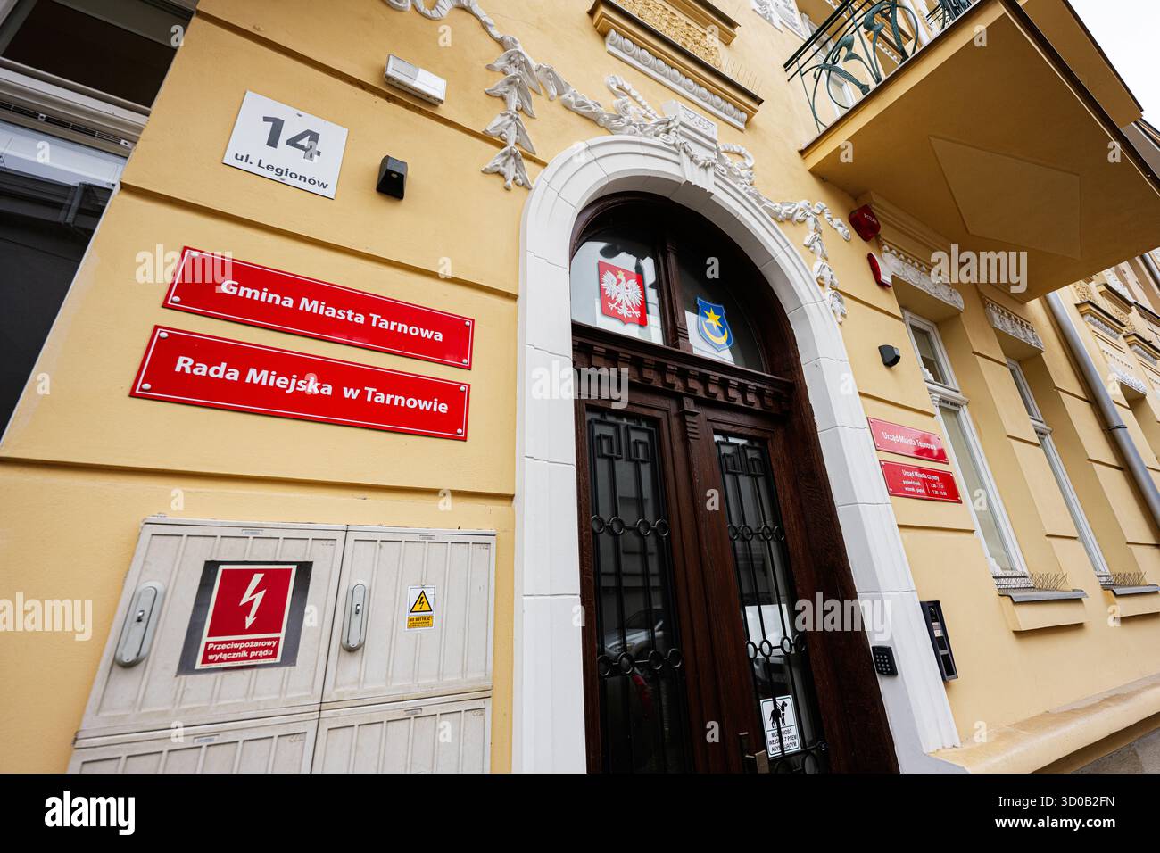 Tarnow, Polen - 10. Oktober 2025: Eingang des städtischen Gebäudes in Tarnow mit roten Tafeln und dekorativer Architektur. Stockfoto