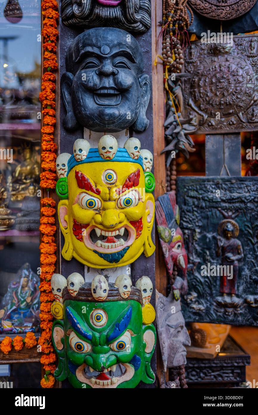 Handgefertigte traditionelle Masken und Metallkunstwerke werden bis 20. Oktober 2025 in einem Souvenirladen in Kathmandu, Nepal, ausgestellt. Stockfoto