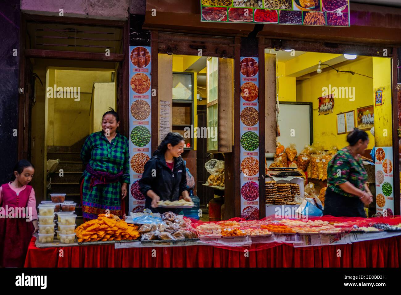 Frauen verkaufen bis 20. Oktober 2025 traditionelle nepalesische Süßigkeiten und Snacks in einem lokalen Geschäft in Kathmandu, Nepal. Stockfoto