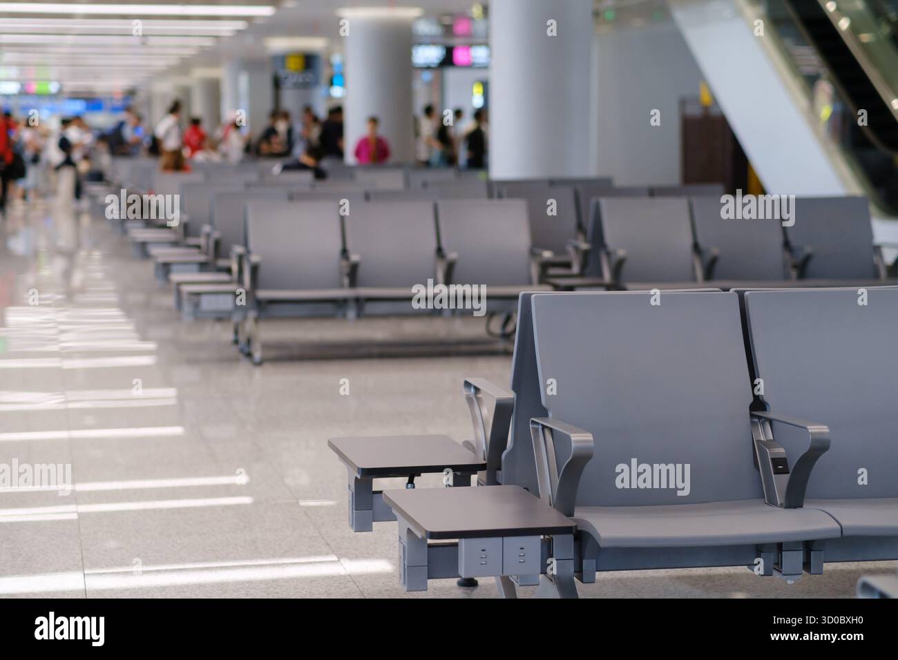 Die Sitzplätze in einem modernen Flughafenterminal bieten während der Mittagszeit einen sauberen, organisierten Raum, der den Reisenden eine angenehme Atmosphäre bietet Stockfoto
