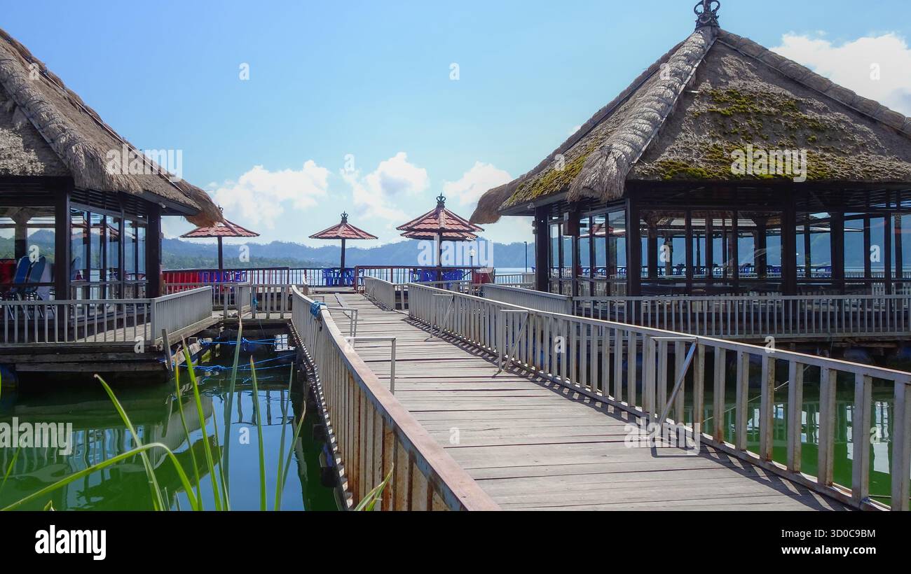 Schwimmendes Restaurant am Lake Danau Batur auf Bali, umgeben von ruhigem Wasser und malerischer Vulkanlandschaft, bietet ein ruhiges kulinarisches Erlebnis. Stockfoto