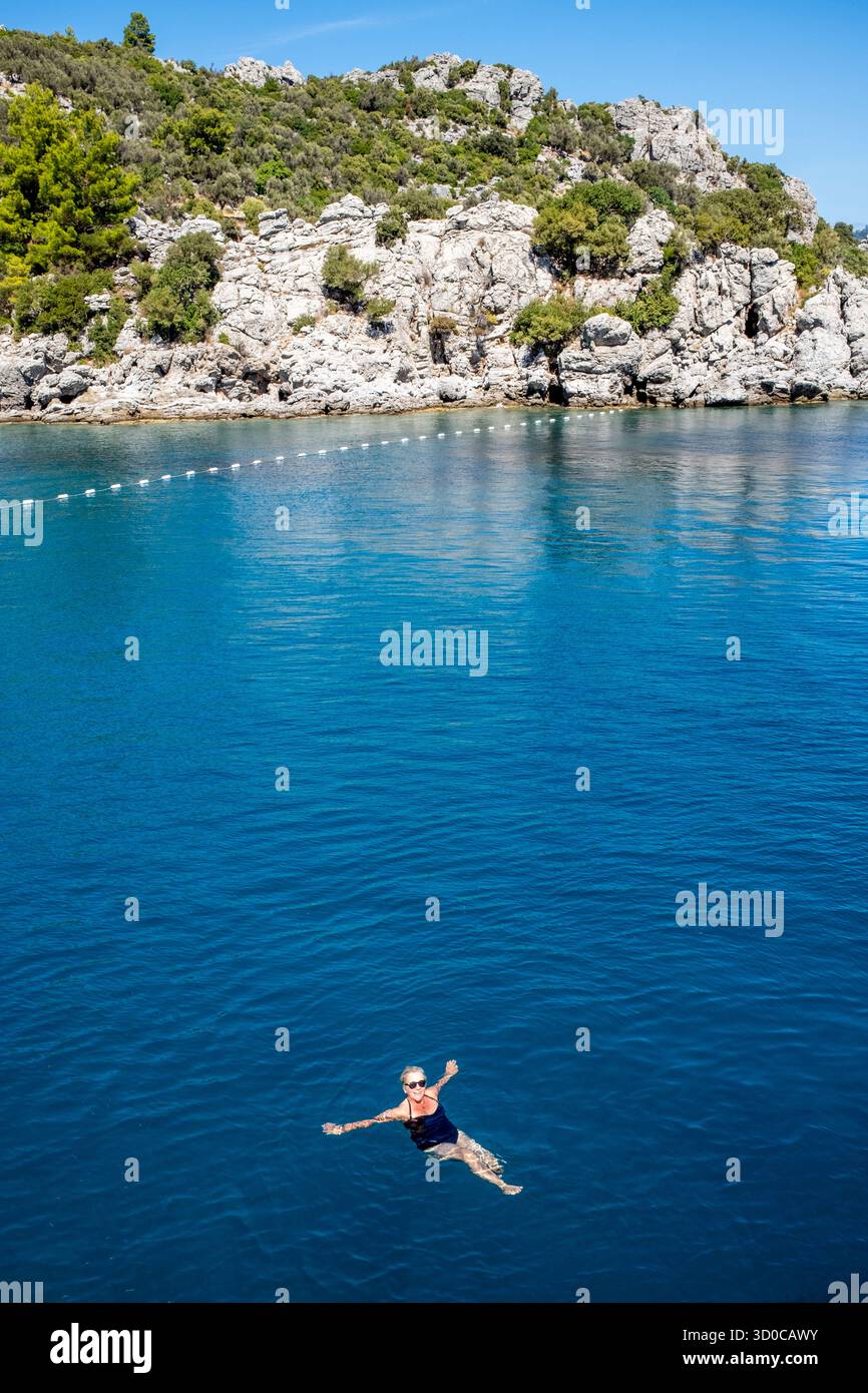 Eine weibliche Touristen schwimmt im Meer während Einer entspannenden ganztägigen Vergnügungsbootfahrt um die Bucht, Marmaris, Provinz Mugla, Türkei. Stockfoto Eine weibliche Touristen schwimmt im Meer während Einer entspannenden ganztägigen Vergnügungsbootfahrt um die Bucht, Marmaris, Provinz Mugla, Türkei. Stockfoto