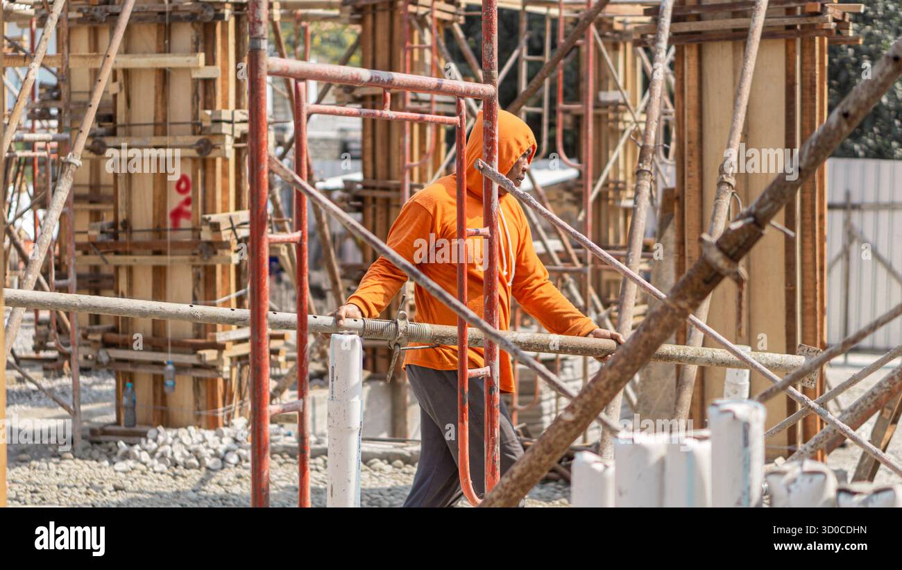 Ein Bauarbeiter, der auf der Baustelle aktiv ist und im Bauprozess Engagement und Präzision zeigt. Stockfoto
