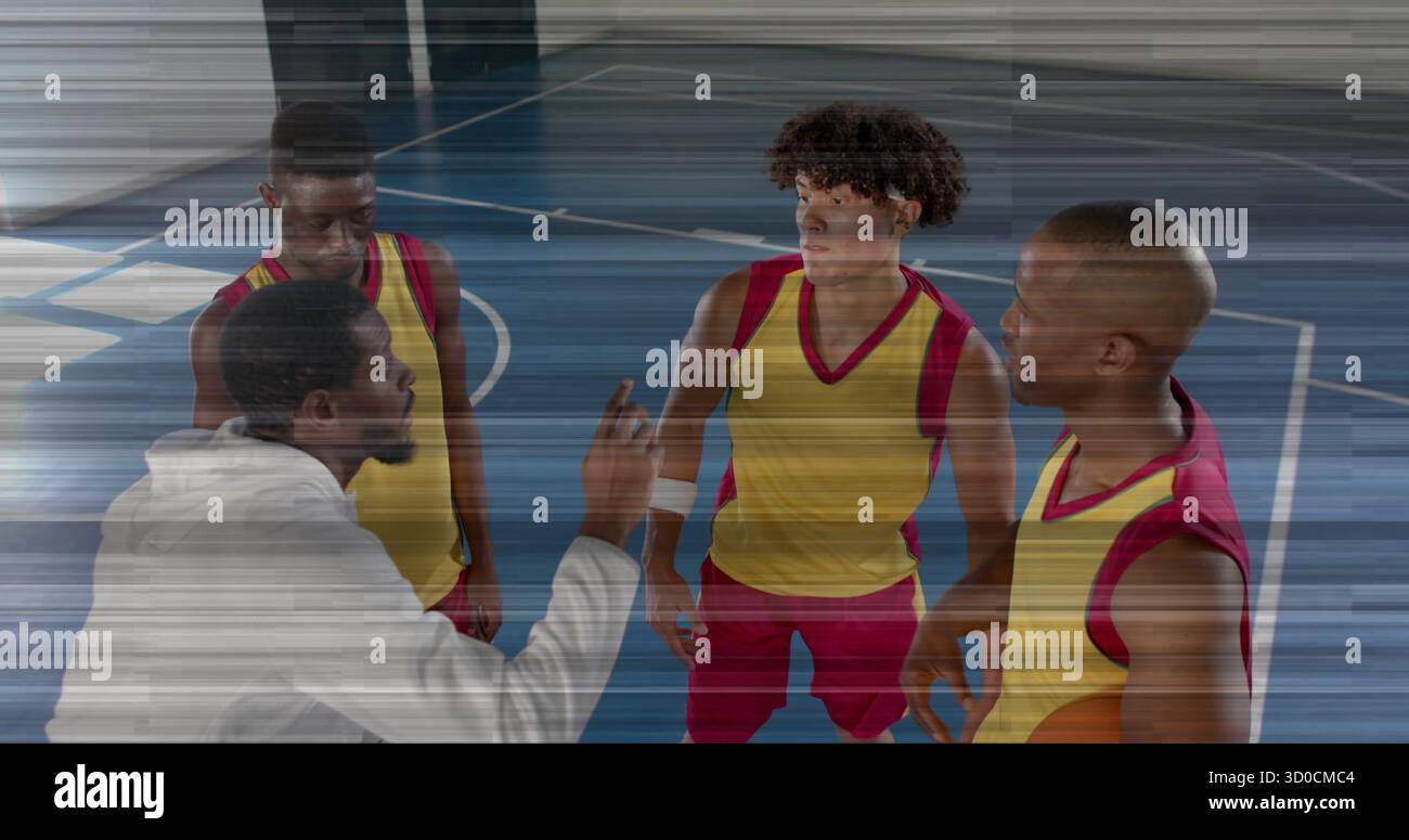 Der Coach hockt und zeigt auf Spieler auf dem Gym-Platz, Basketball und gelben roten Trikots Stockfoto