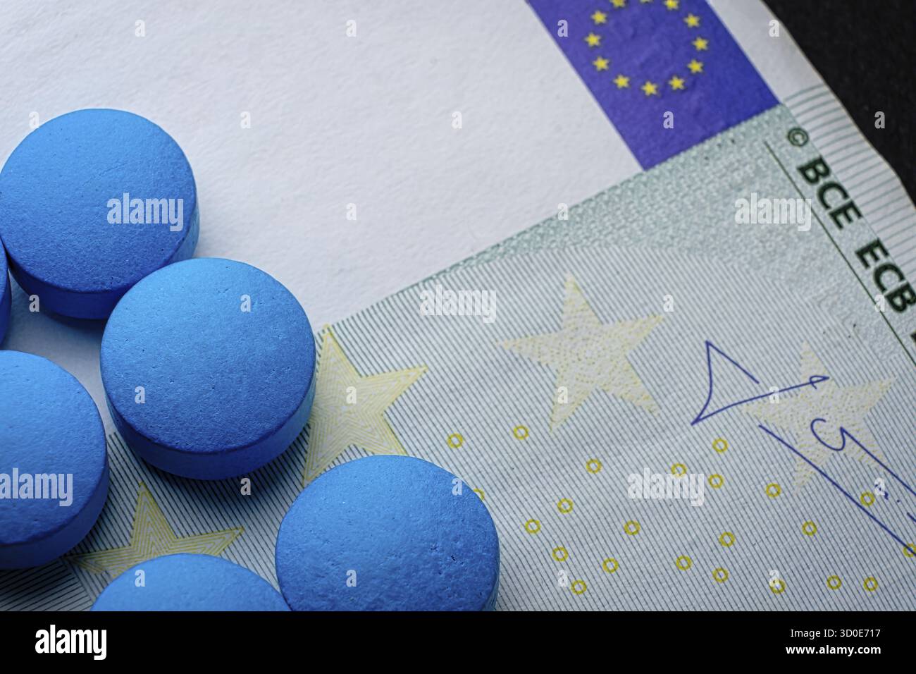 Gesundheitsplan. Blaue Tabletten Pille Makro auf Euro-Rechnung. Drogenmissbrauch Stockfoto