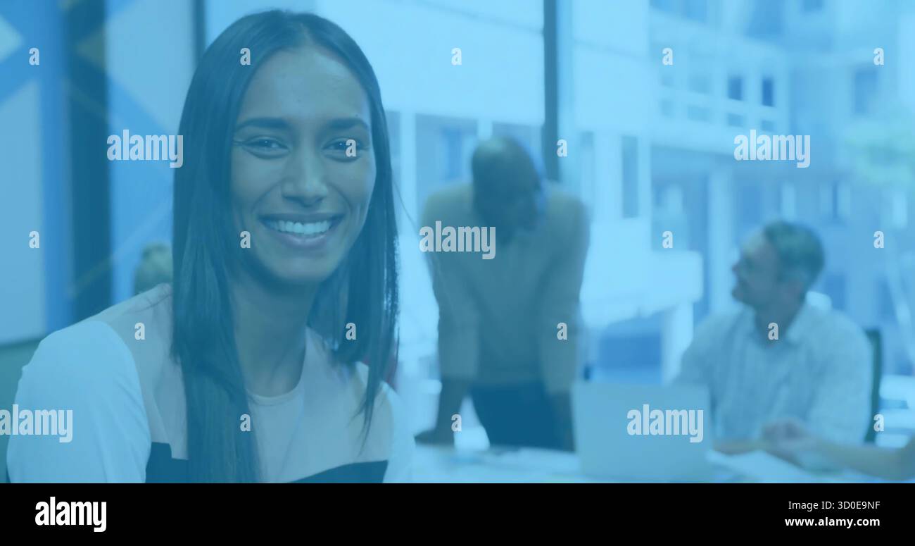 Lächelnde Frau mit farbgeblockter Bluse am Konferenztisch mit Laptop, Kopierraum Stockfoto