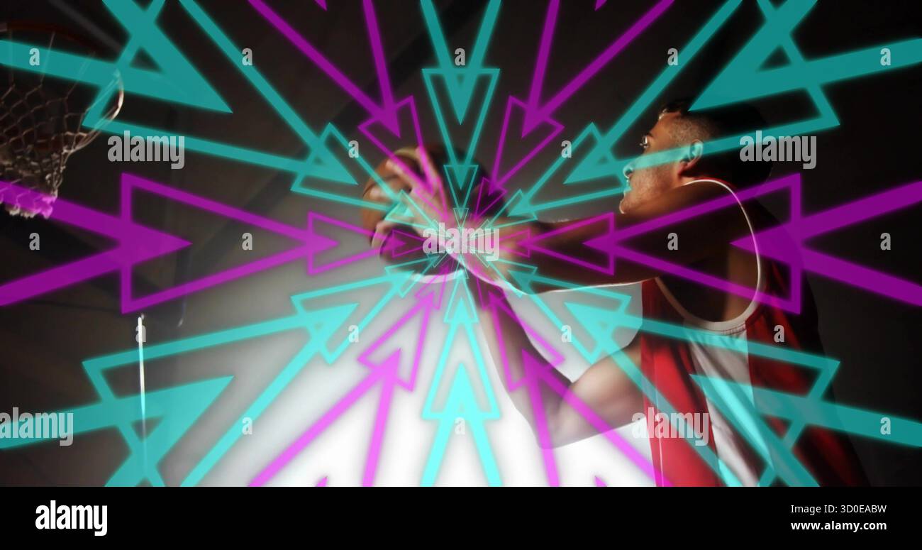 Springender Basketballspieler, der den Ball hält und sich im Fitnessstudio mit blauen und violetten Pfeilen in Richtung Basketball streckt Stockfoto