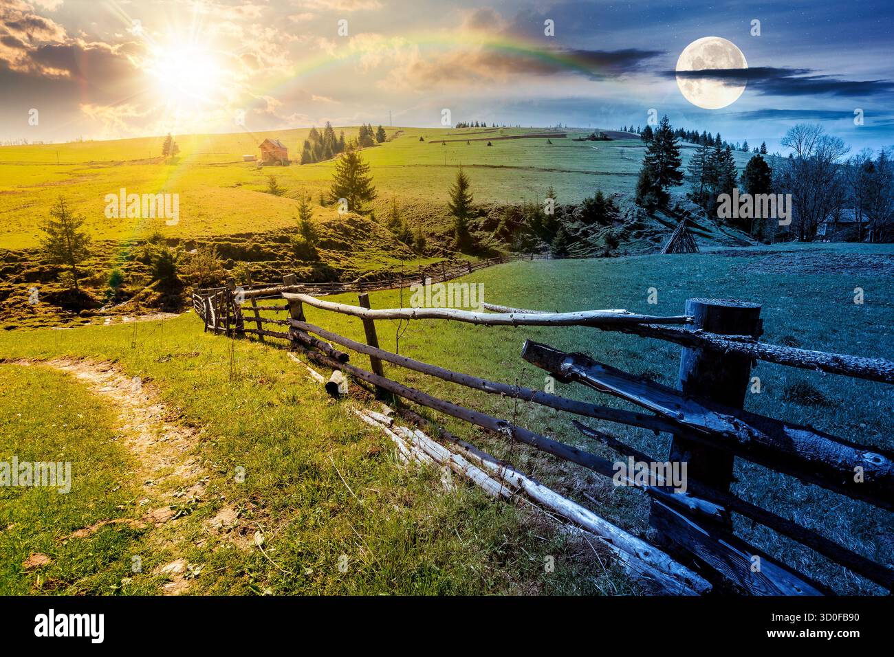Wunderschöne ländliche Landschaft in Bergen am Frühlingsnachtgleiche. Tag- und Nachtzeitwechsel. Straße in der Nähe des Zauns durch die Weide mit Heuhaufen und Betrüger Stockfoto
