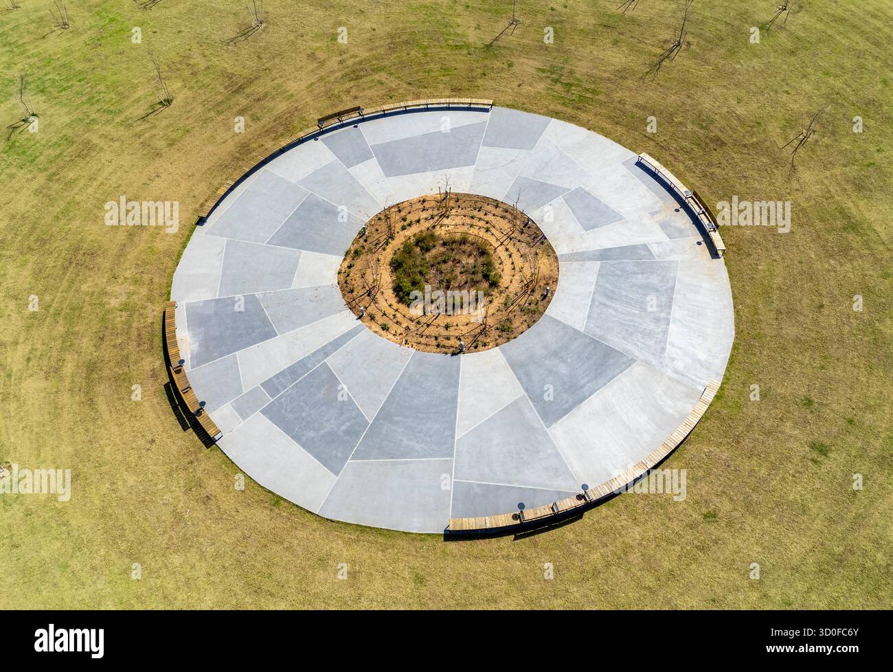 Aus der Vogelperspektive eines kreisrunden Betonbauwerks, umgeben von trockenem Gras, der einen geometrischen Kontrast zur natürlichen Landschaft in Nahariyya, North District, Israel schafft. Stockfoto