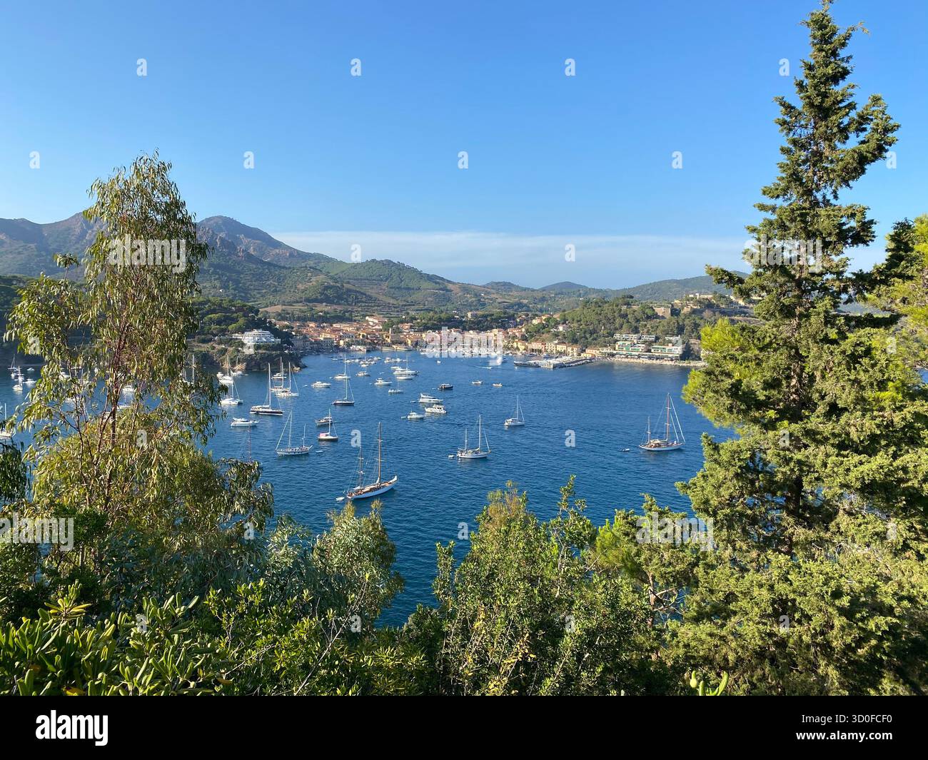 Heller Sommertag auf der Insel Elba Italien mit einem malerischen Blick auf die Bucht voller Yachten und Segelboote vom Berggipfel aus gesehen. - Smartphone-aufgenommenes Stockfoto