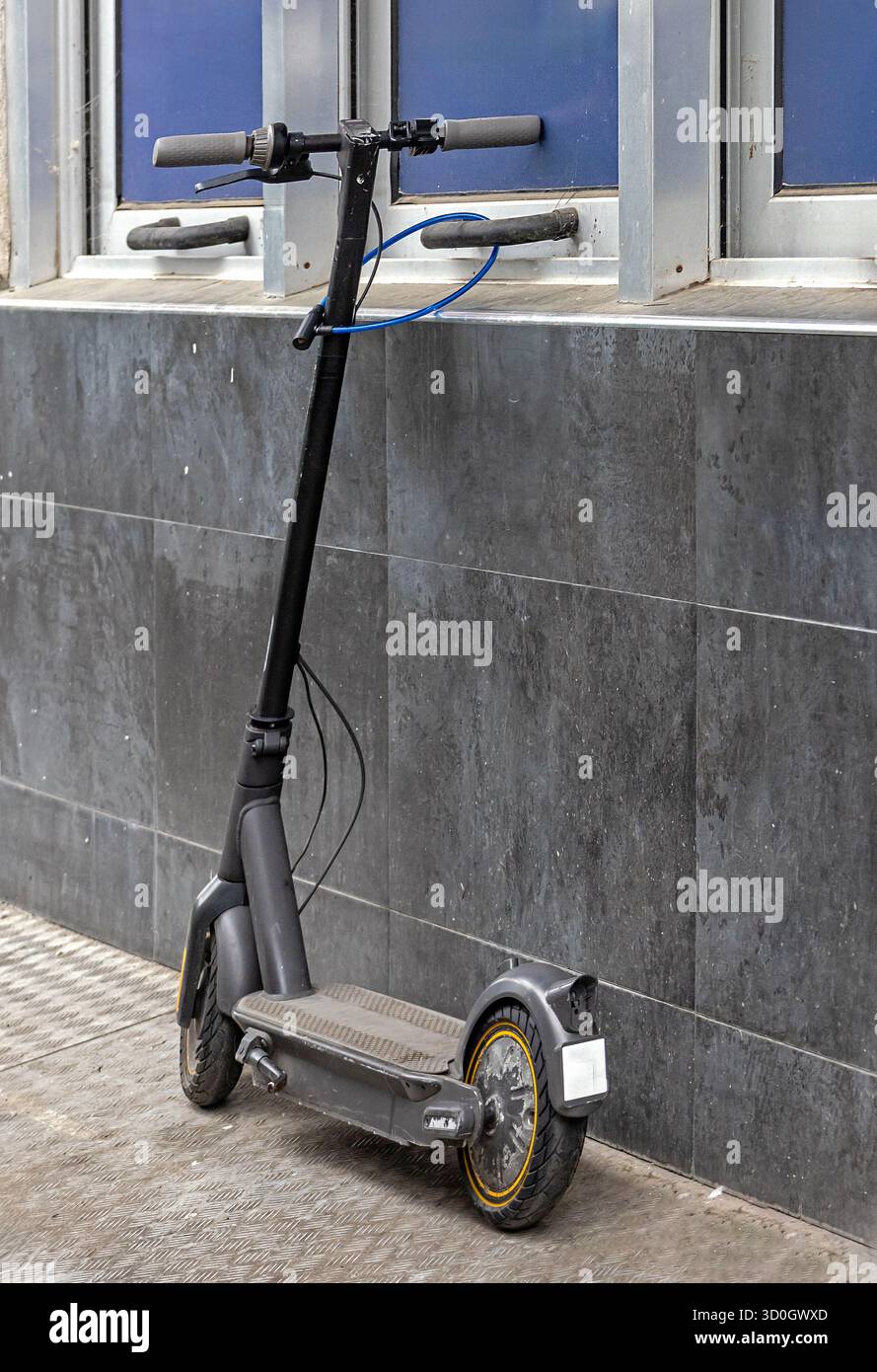 Persönliche elektrische Roller-Vorrichtung, die draußen auf einem Straßenbelag steht Stockfoto