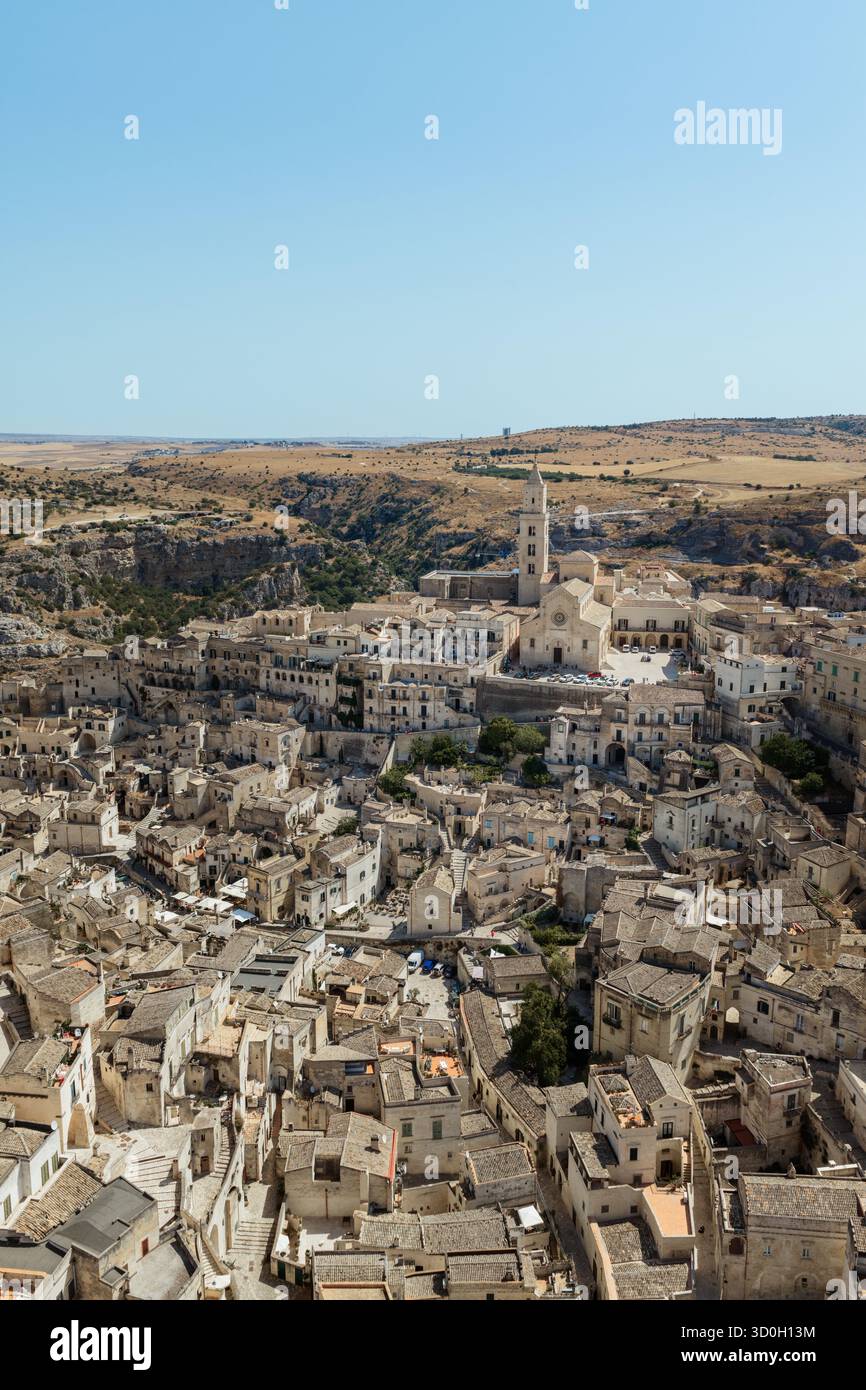 Blick aus der Vogelperspektive auf die alten Häuser stürzt die sonnengebackenen Hügel hinunter, gekrönt von dem berühmten Dom, Matera, Basilicata, Italien. Stockfoto