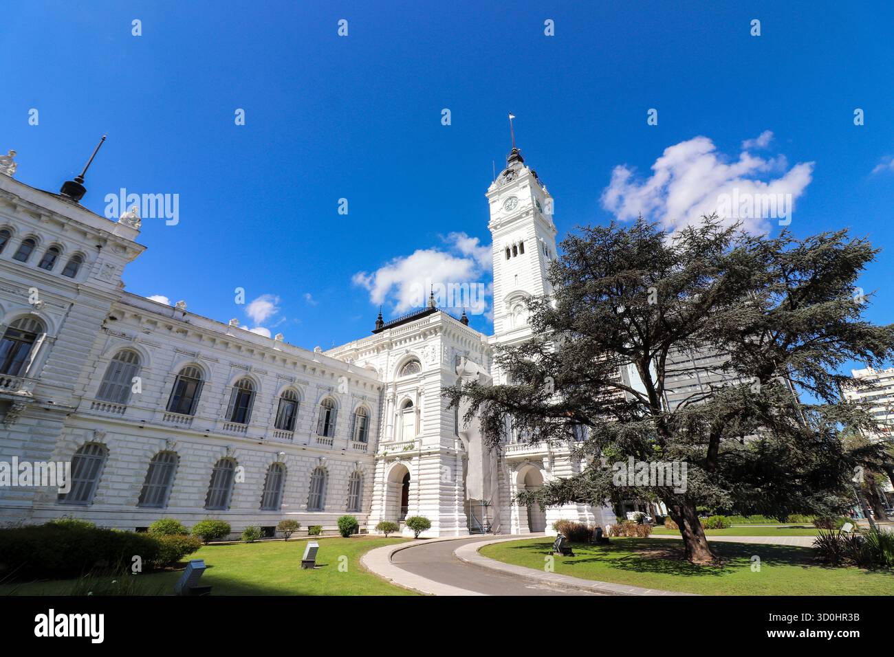 Seitenwinkel der Gemeinde La Plata, Argentinien. Der imposante Glockenturm, die klassische Architektur und der weitläufige Garten an einem sonnigen blauen Tag. Stockfoto