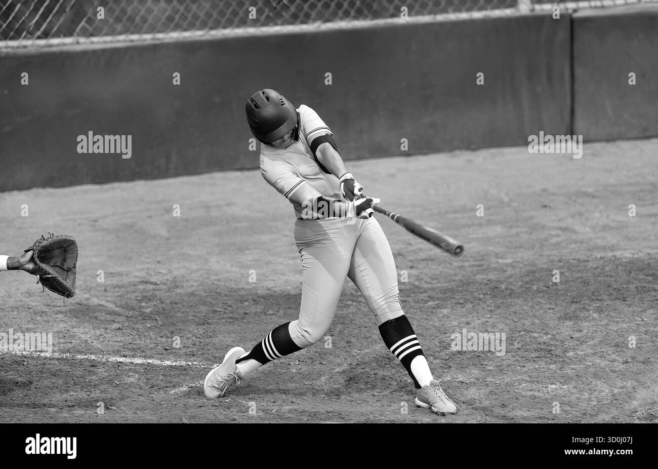 Ein Baseballspieler wird in Full Motion Action in Schwarz-weiß-Bildern als Swinging the Fledermaus aufgenommen Stockfoto