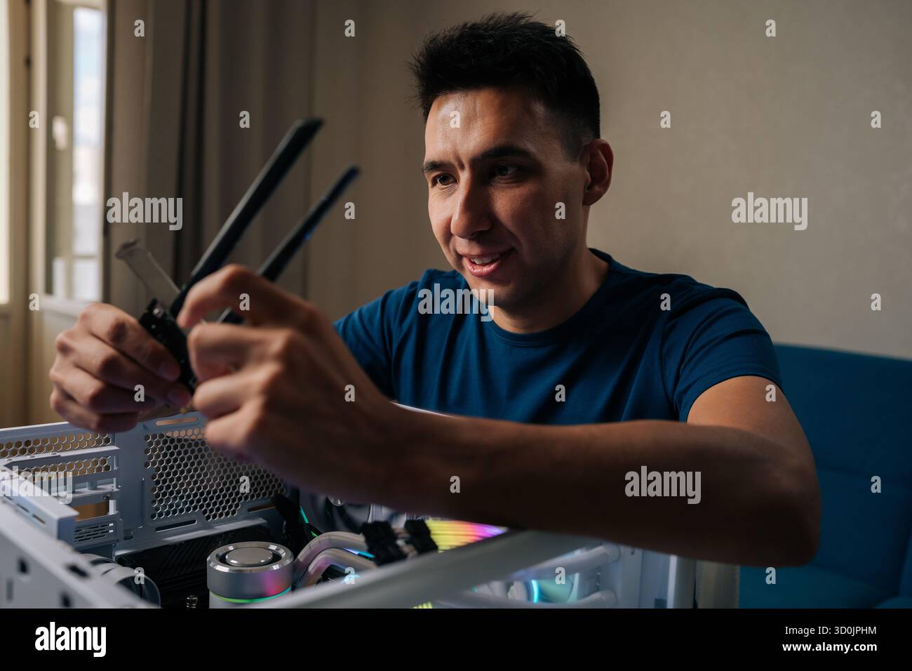 Positiver Computertechniker, der ein drahtloses Netzwerkmodul in einen benutzerdefinierten Desktop-Computer einfügt, verbessert die Systemkonnektivität für Zuverlässigkeit Stockfoto