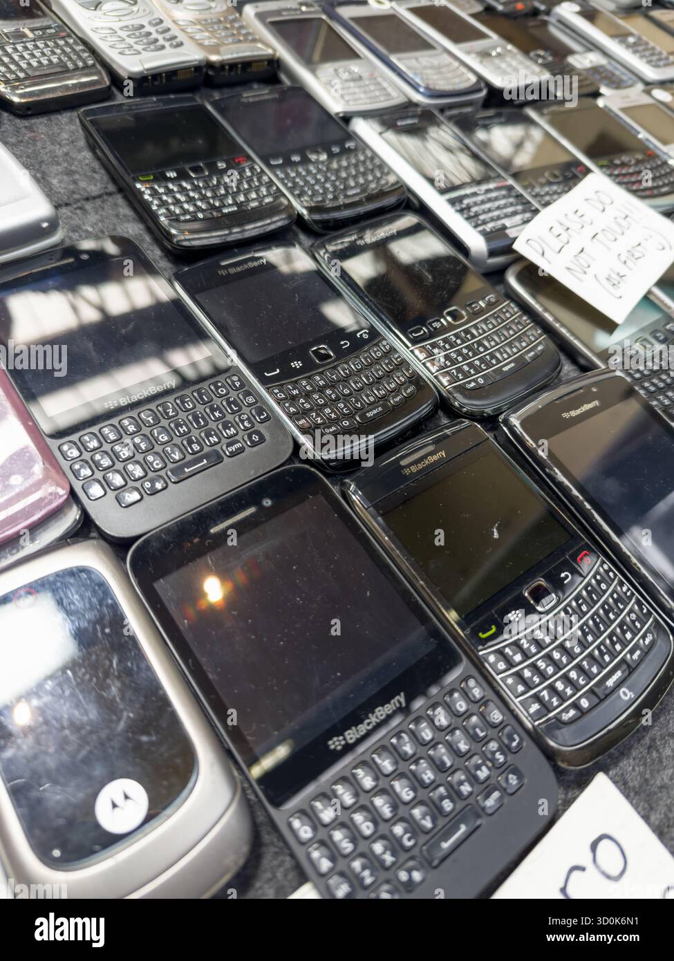 Sammlung klassischer und funktionaler BlackBerry-Mobiltelefone auf einem Tisch – mit klassischen Smartphone-Designs aus den frühen 2000er Jahren Stockfoto