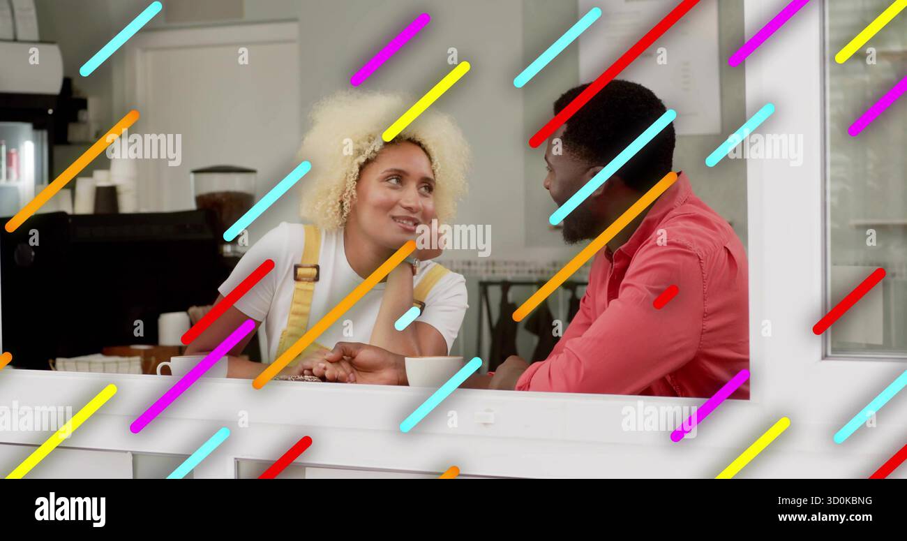 Eine Frau in gelbem Overall und ein Mann in rosa Hemd, der an der Kaffeekasse plaudert und Tassen hält Stockfoto