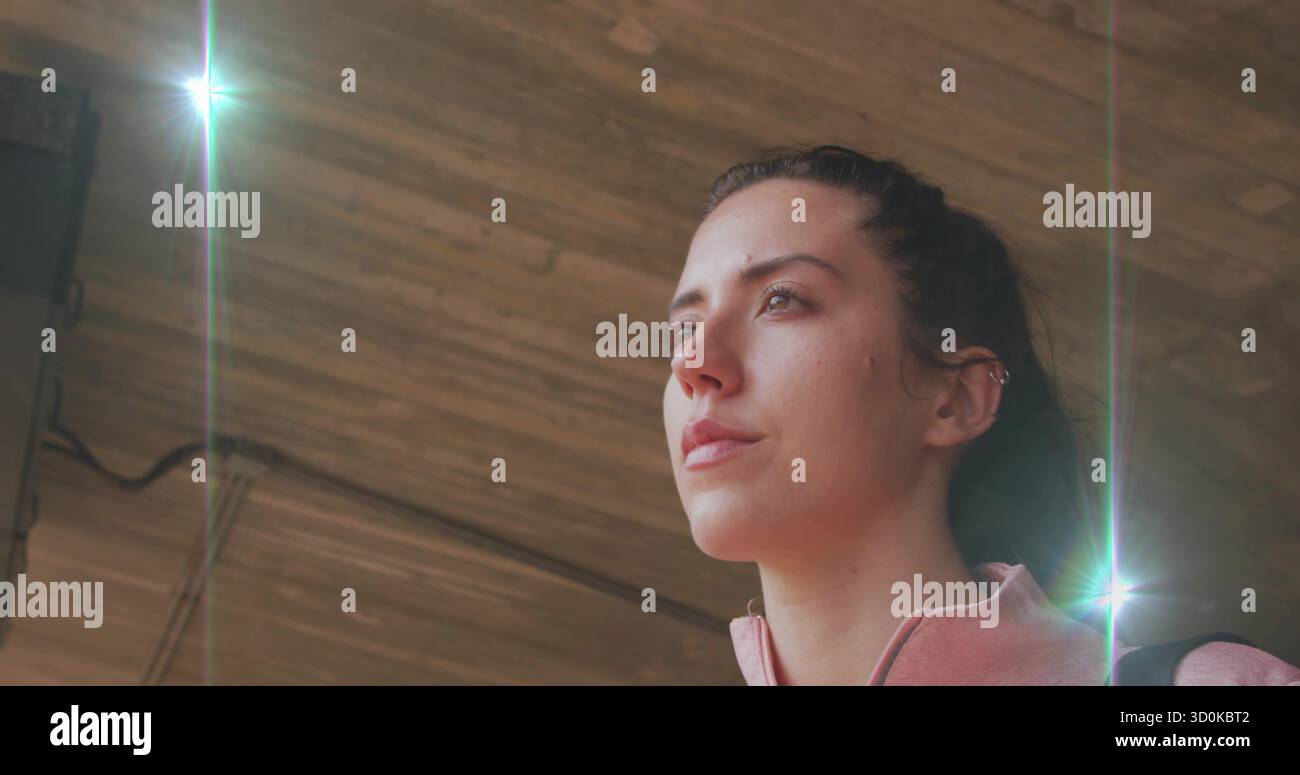 Eine Frau mit rosafarbenem Reißverschluss unter der Lattendecke mit Bühnenlicht im Studio, Kopierraum Stockfoto
