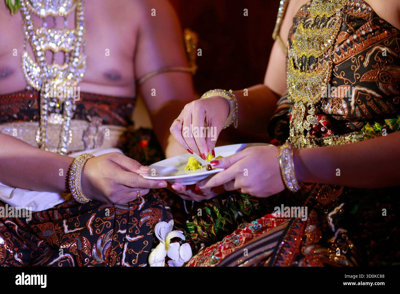 Die Hände der Brautpaare, die der Zeremonie folgen, ernähren sich gegenseitig in der Tradition der javanischen Ehe als Ausdruck gegenseitiger Liebe. Stockfoto