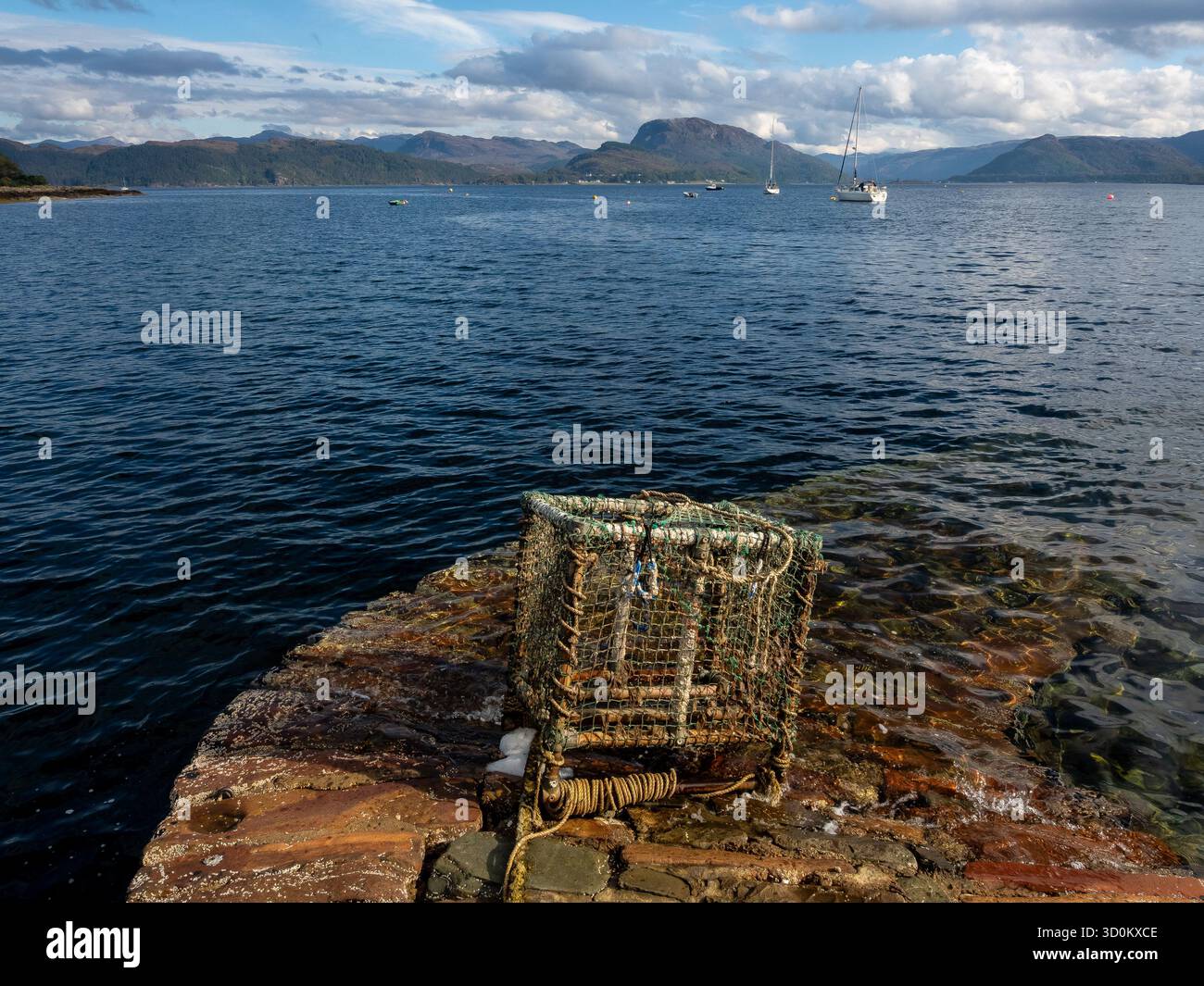 Hummertopf am Hafenrand von Plockton mit Blick auf die ruhige Bucht Stockfoto