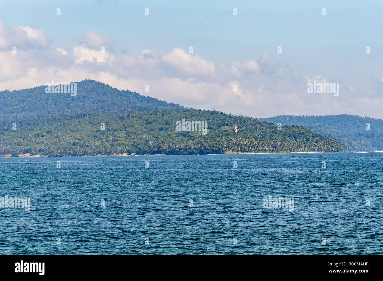 Panoramablick auf das Meer mit weit entfernten bewaldeten Inseln und ruhigem Wasser bei Sonnenaufgang Stockfoto