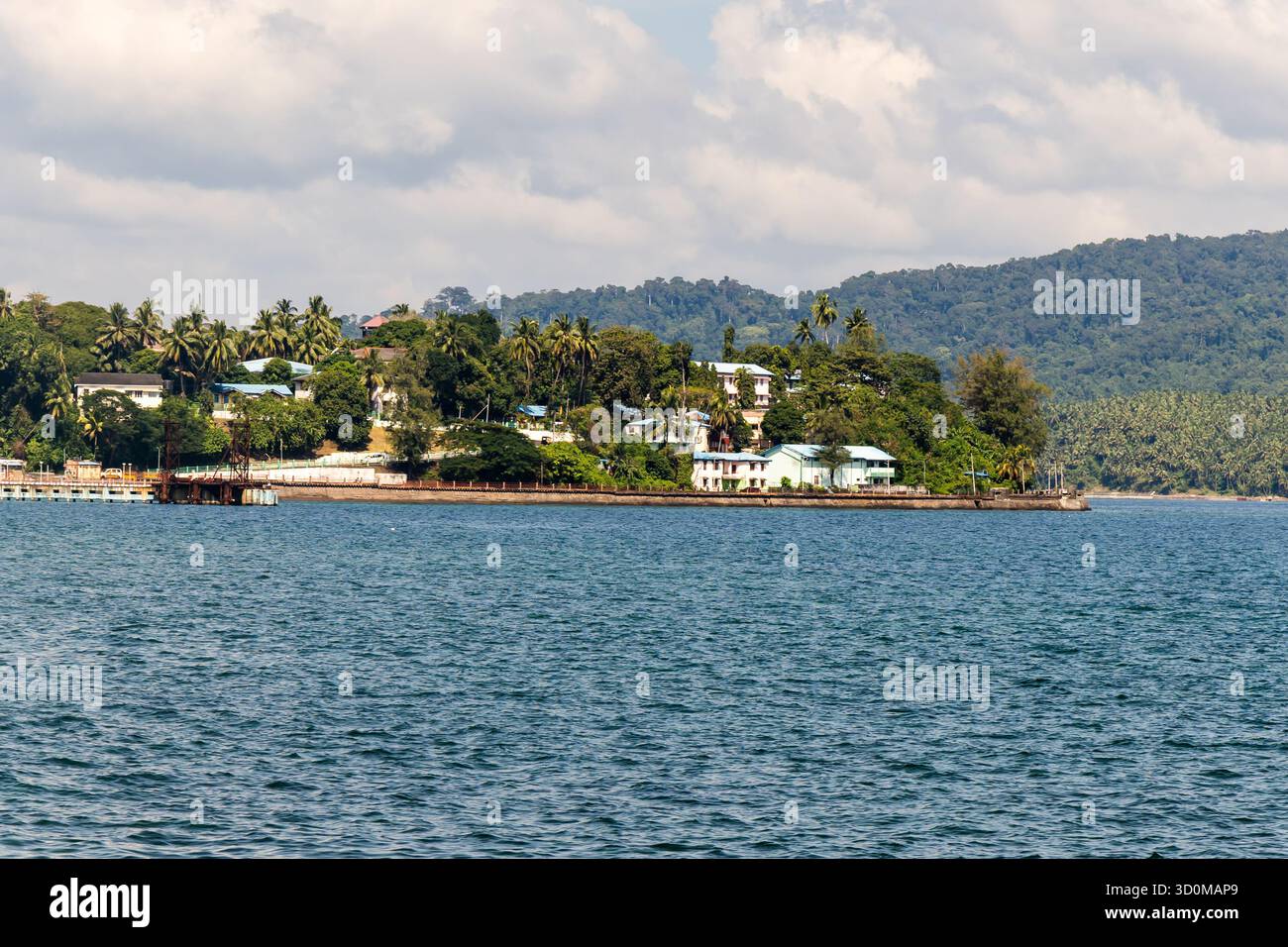 Panoramablick auf das Meer mit weit entfernten bewaldeten Inseln und ruhigem Wasser bei Sonnenaufgang Stockfoto
