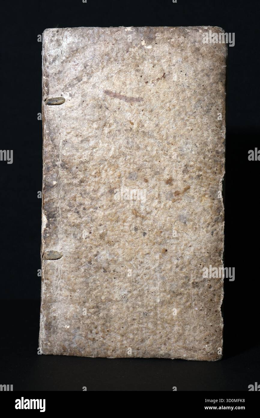 Unverschmückter, strukturierter Umschlag eines sehr alten Buches, wahrscheinlich gebunden in rauem Pergament oder hellem, kieselfarbenem Leder. Abnutzung, Flecken und Alterung der Feavy Stockfoto