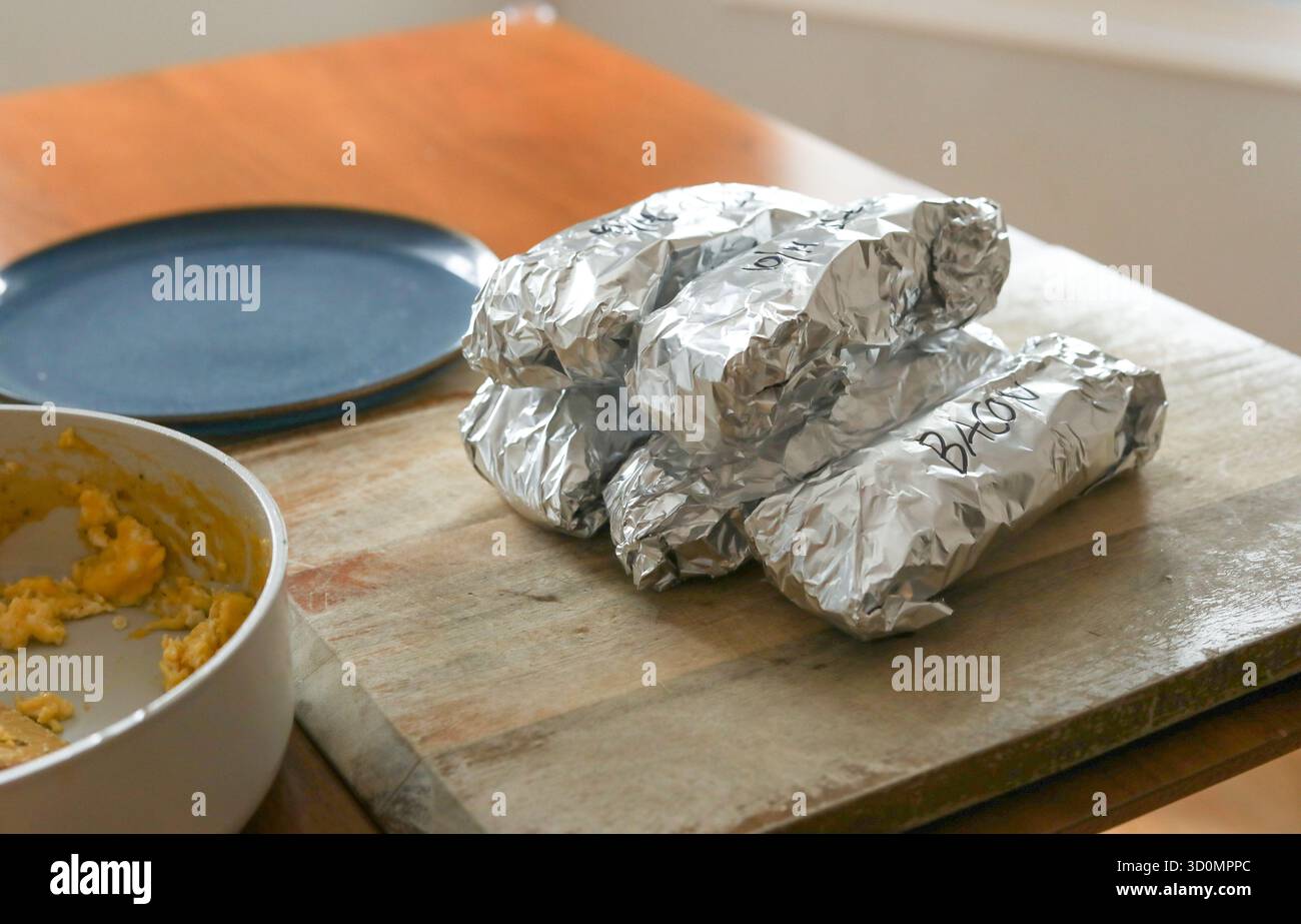 Stapel Burritos für die Mahlzeit in Aluminiumfolie bereit für den Gefrierschrank Stockfoto