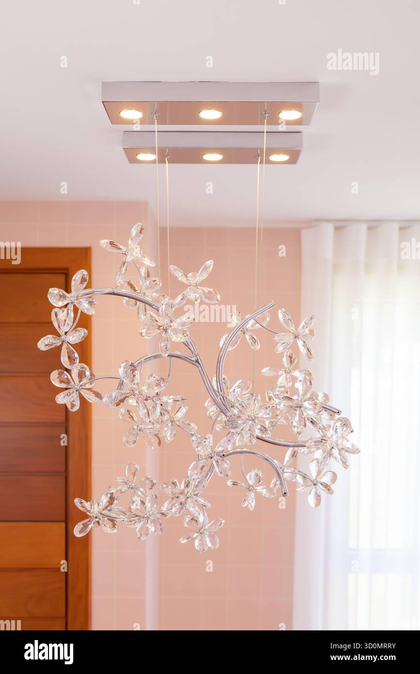 Eine Pendelleuchte aus Kristall befindet sich in einem modernen Eingangsbereich eines Hauses, Stockfoto