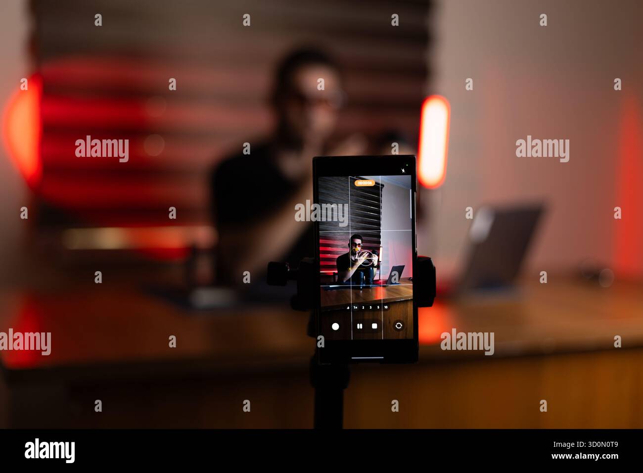 Die Person nimmt mit einem Smartphone einen Podcast oder einen Videostream auf Stockfoto