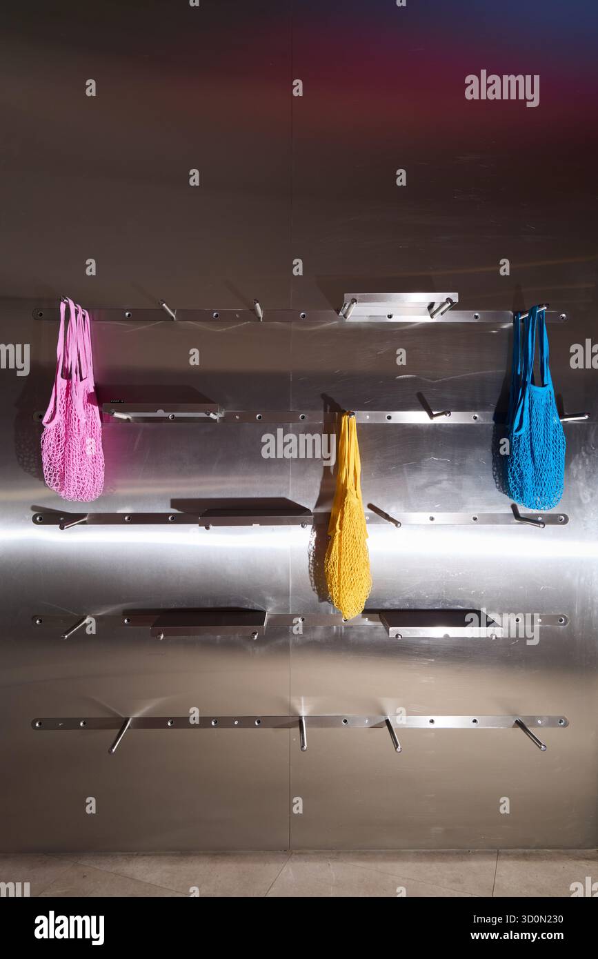 Eine Kollektion von farbenfrohen Taschen, die wunderschön auf einer eleganten, modernen Wanddekoration präsentiert werden Stockfoto