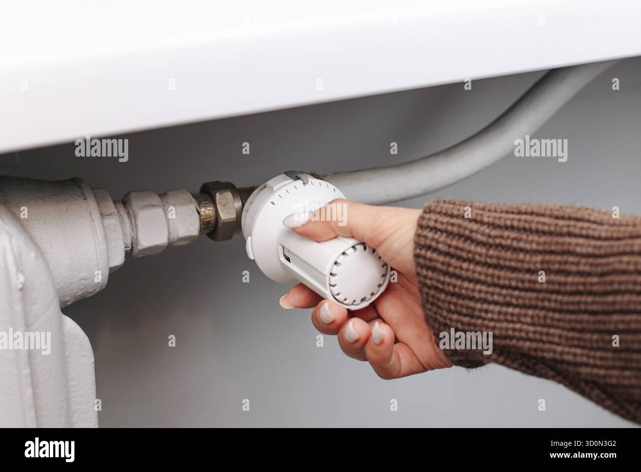 Kühlerthermostat von Hand einstellen. Temperaturregelung für Heizelemente. Energieeinsparung im Winter. Details zur Haushaltsheizung. Stockfoto