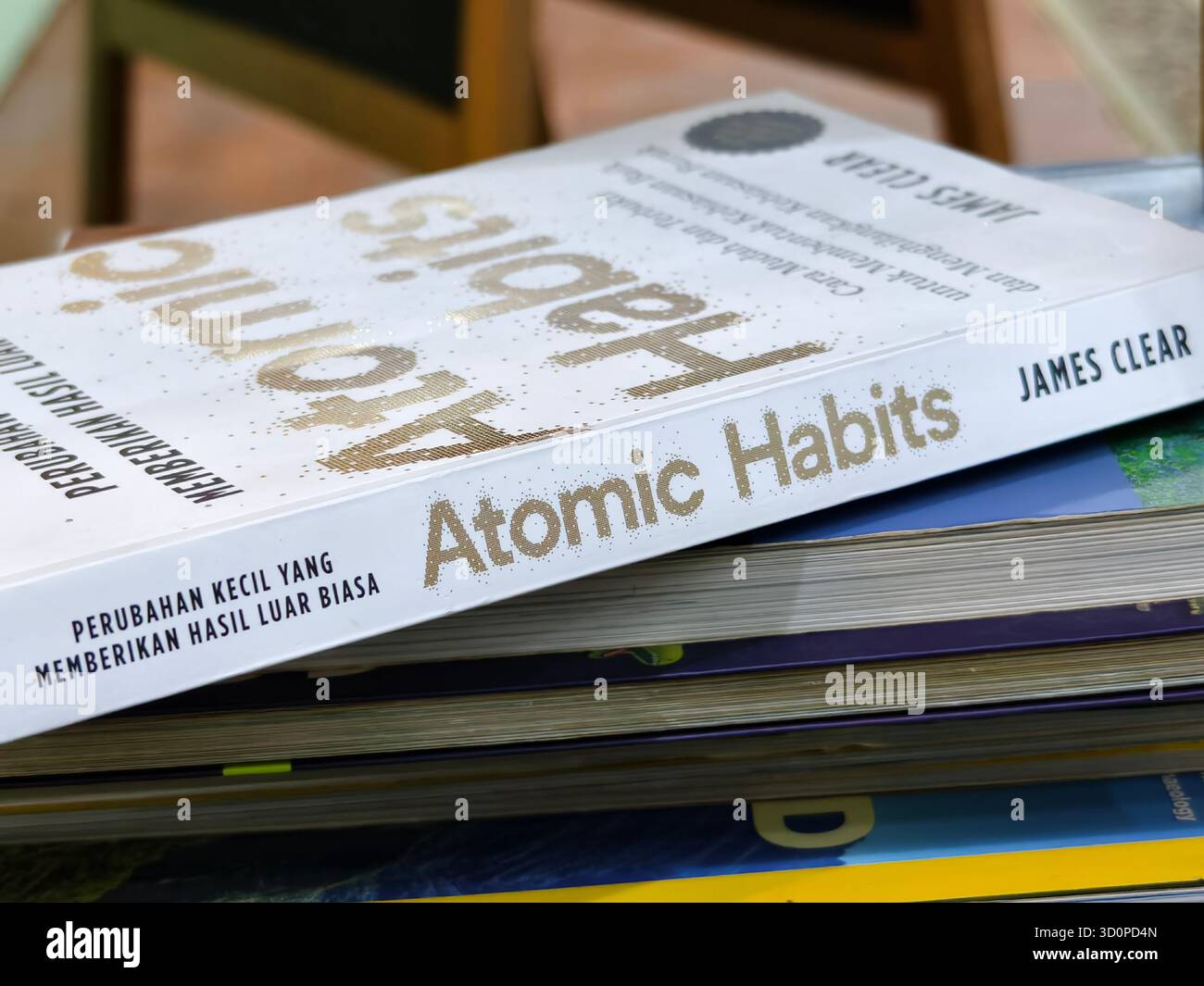 Denpasar, Bali, Indonesien – 23. Oktober 2025: Der Buchcover von Atomic Habits des Autors James Clear bietet Selbsthilfeanleitungen für den Aufbau guter Gewohnheiten Stockfoto