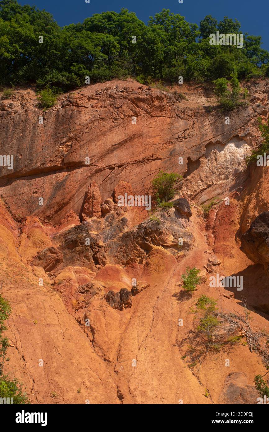 Erodierte Felswände mit sichtbaren Gesteinsschichten im Bergwerk Gánt Bauxite, Ungarn. Stockfoto