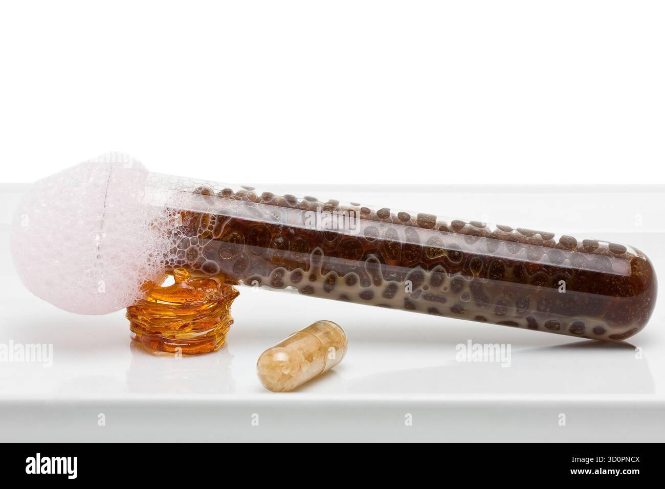 Molekulare Gastronomie - Kaffeekaviar im Reagenzglas mit rosa Milchschaum und Zuckerpille Stockfoto