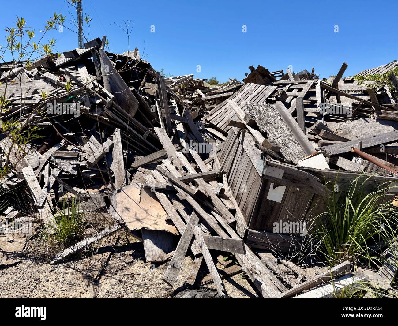 Ein Haufen zusammengebrochener Holzschutt unter blauem Himmel Stockfoto