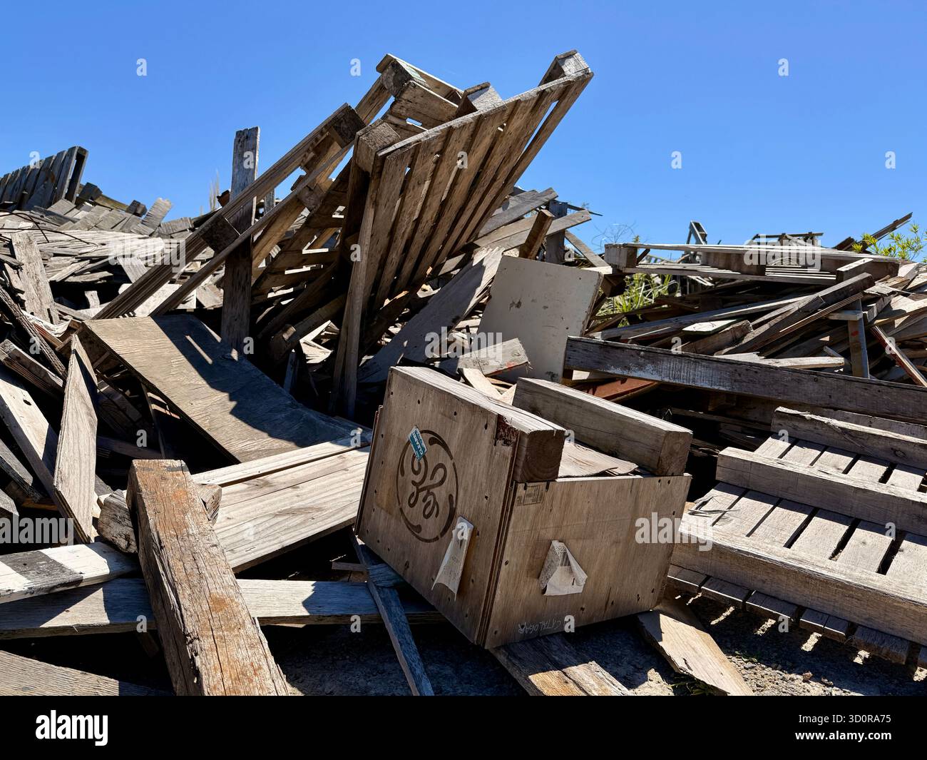 Ein Haufen zusammengebrochener Holzschutt unter blauem Himmel Stockfoto