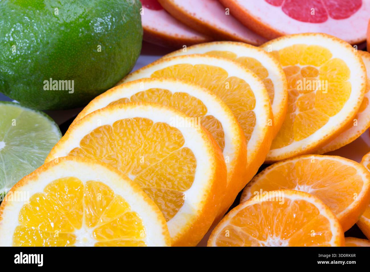 Hintergrund von Fruchtscheiben aus roter Grapefruit, grüner Limette und Mandarine, Nahaufnahme Stockfoto
