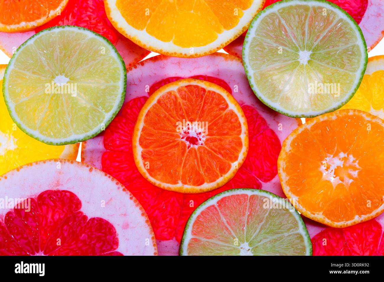 Hintergrund von Fruchtscheiben aus roter Grapefruit, grüner Limette und Mandarine, Nahaufnahme Stockfoto
