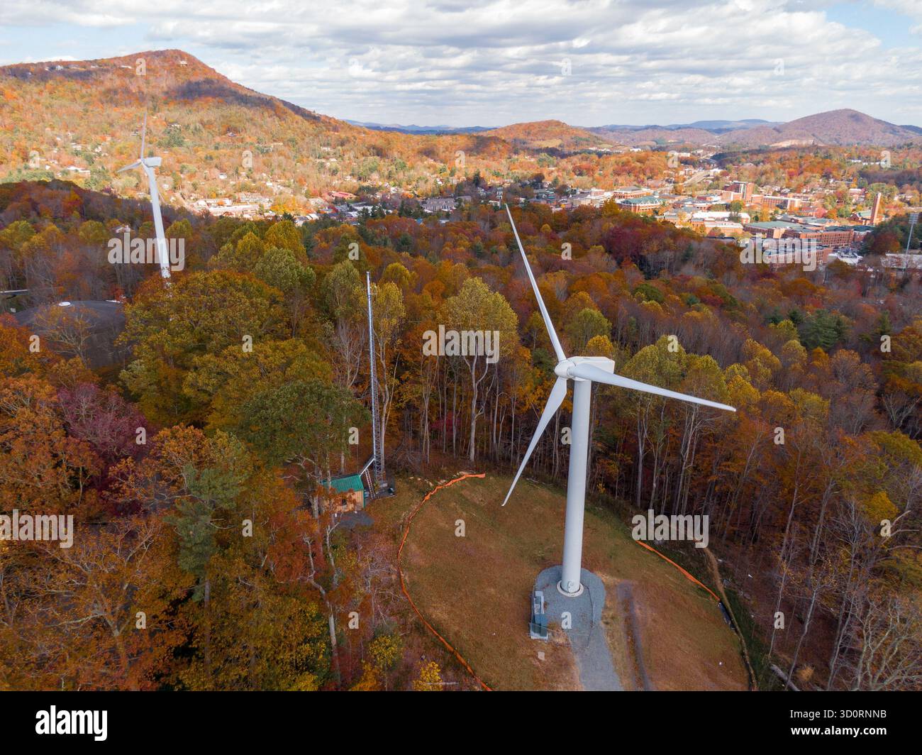 Die Windturbine der Appalachian State University bildet eine Silhouette gegen die Blue Ridge Mountains in Boone, North Carolina Stockfoto
